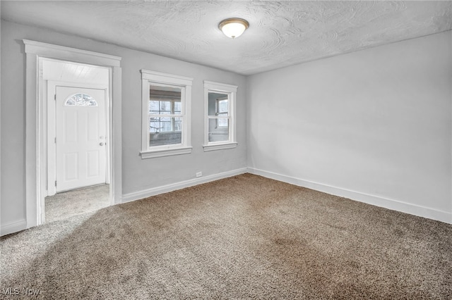 entryway featuring carpet floors, a textured ceiling, and baseboards