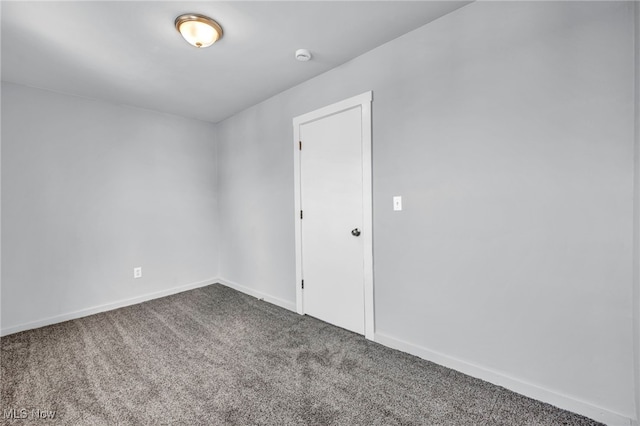 spare room featuring carpet and baseboards