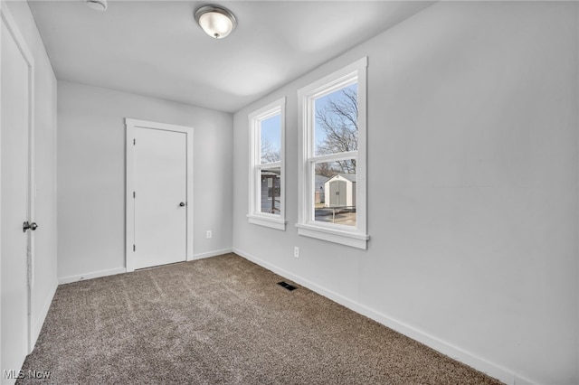 unfurnished bedroom featuring carpet flooring, visible vents, and baseboards