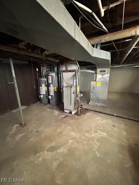 unfinished below grade area featuring water heater, gas water heater, and heating unit