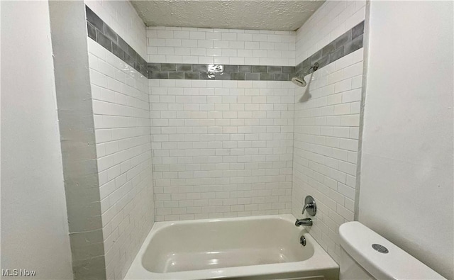 full bathroom with toilet,  shower combination, and a textured ceiling