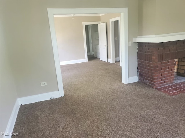 interior space with carpet floors, a brick fireplace, and baseboards