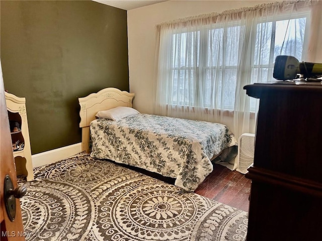 bedroom featuring wood finished floors and baseboards