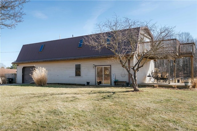 rear view of house featuring a lawn, a deck, and a gambrel roof