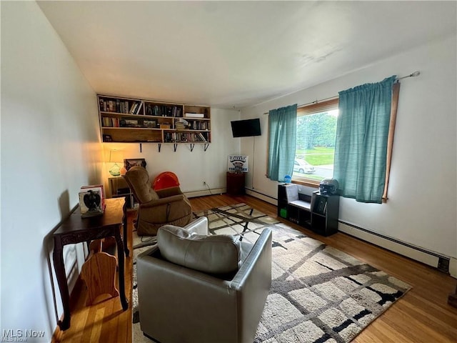 living room featuring a baseboard heating unit and wood finished floors