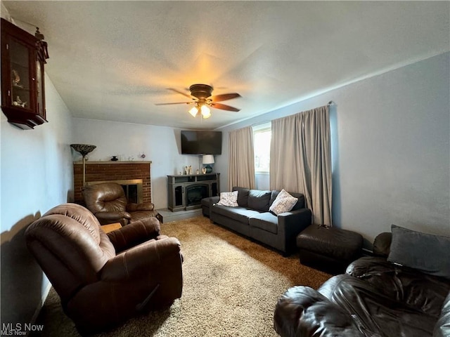 carpeted living area featuring a textured ceiling, a brick fireplace, and a ceiling fan