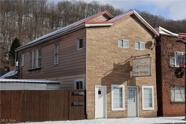 view of front of house with stone siding and fence