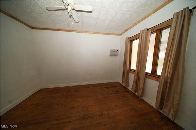 unfurnished room featuring baseboards, dark wood finished floors, a ceiling fan, and crown molding