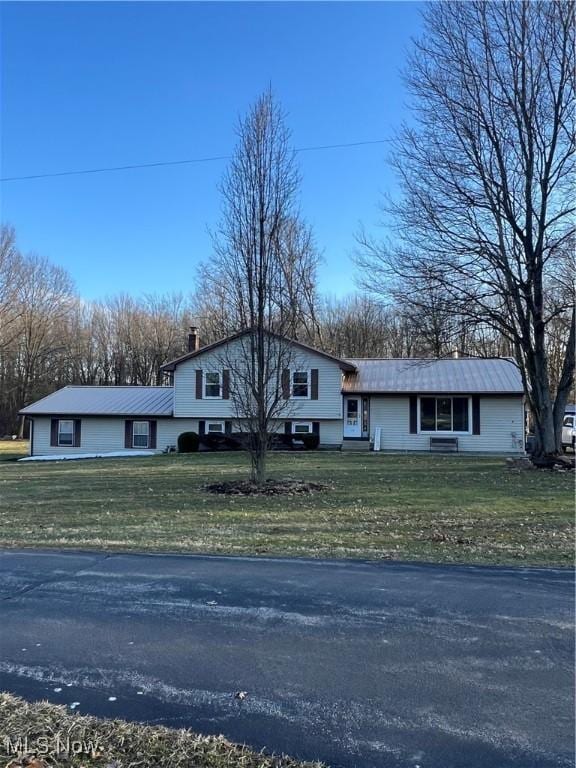 split level home featuring a front lawn and a chimney