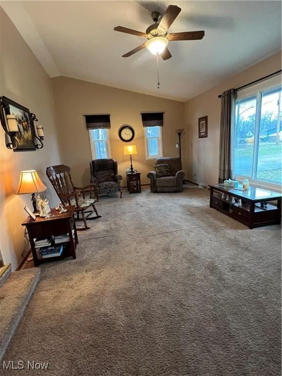 carpeted living area with vaulted ceiling, a wealth of natural light, and a ceiling fan