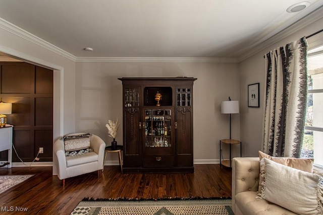 sitting room featuring baseboards, ornamental molding, and wood finished floors