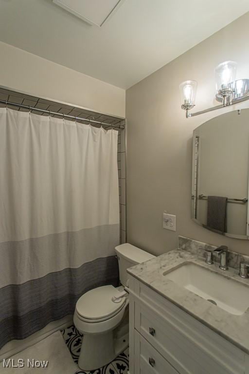 bathroom featuring toilet, a shower with shower curtain, and vanity