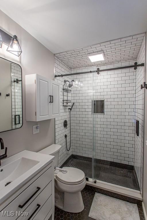 bathroom featuring a stall shower, vanity, and toilet