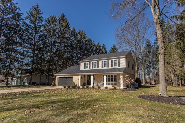 view of front of home with a garage, driveway, covered porch, a front yard, and brick siding