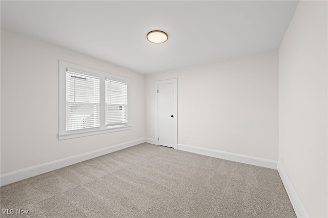 unfurnished room featuring carpet flooring and baseboards