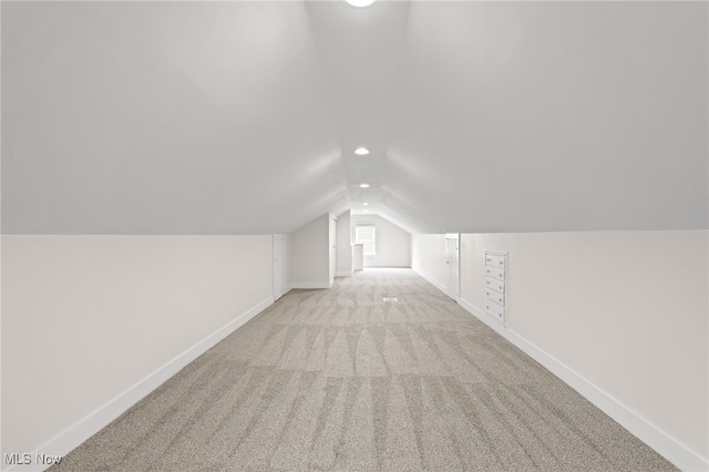 additional living space with recessed lighting, baseboards, vaulted ceiling, and light colored carpet