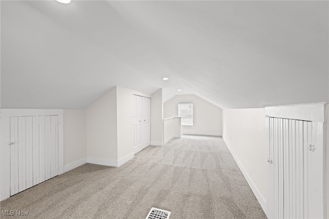 additional living space featuring lofted ceiling, carpet flooring, visible vents, and baseboards