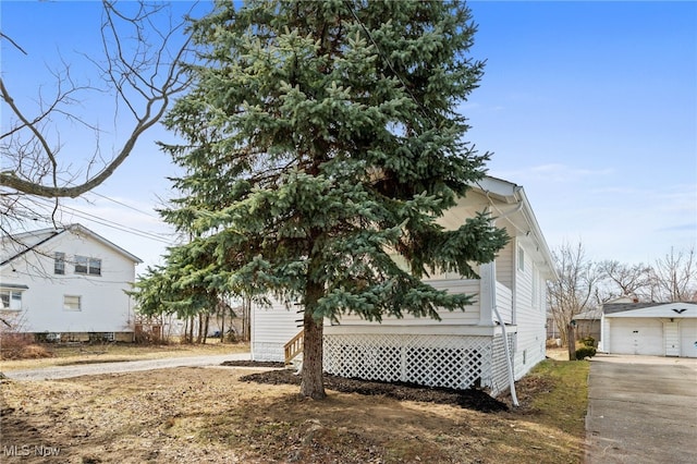 view of property exterior featuring an outbuilding and a detached garage