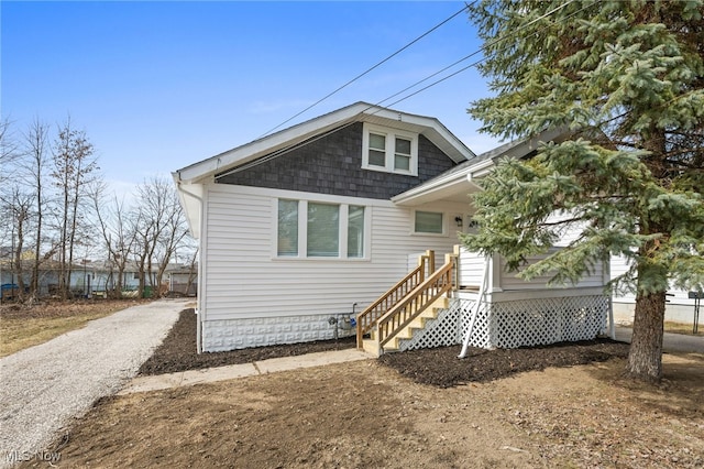 back of property featuring entry steps and driveway