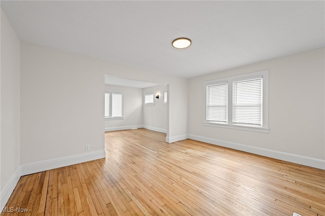 empty room with wood-type flooring and baseboards