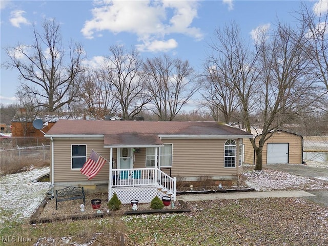 view of front of house with a garage, fence, and an outdoor structure