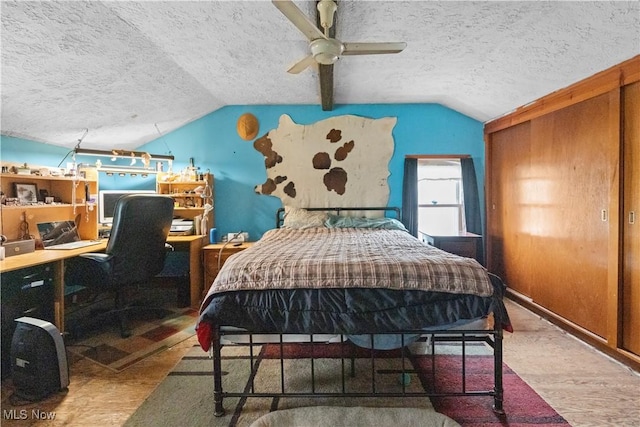 bedroom featuring lofted ceiling, a textured ceiling, and wood finished floors