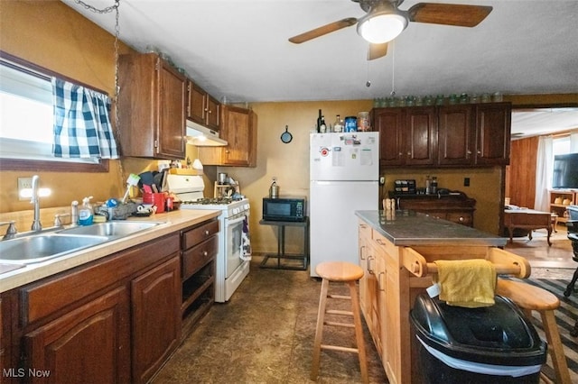 kitchen featuring white appliances, ceiling fan, under cabinet range hood, and a sink