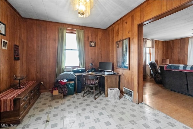 office space with visible vents, wood walls, and light floors