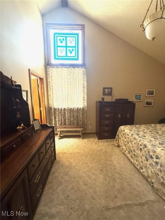 bedroom featuring lofted ceiling and light carpet