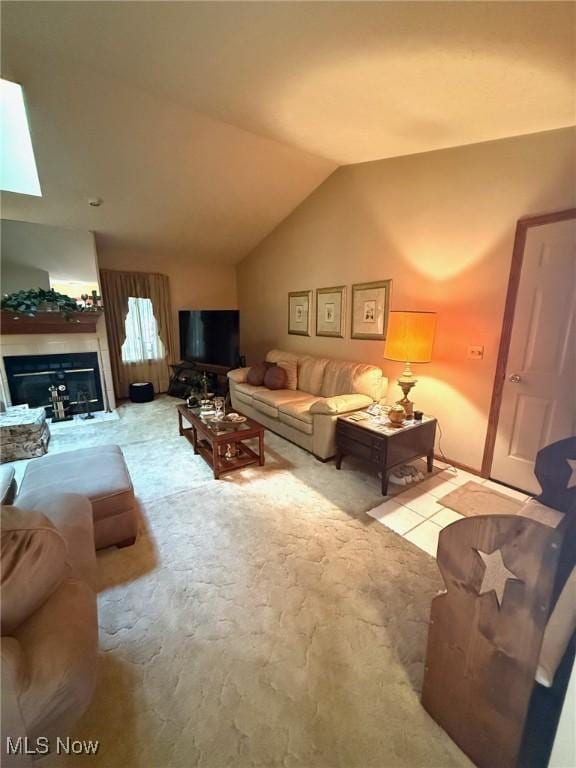 living room featuring lofted ceiling and a glass covered fireplace