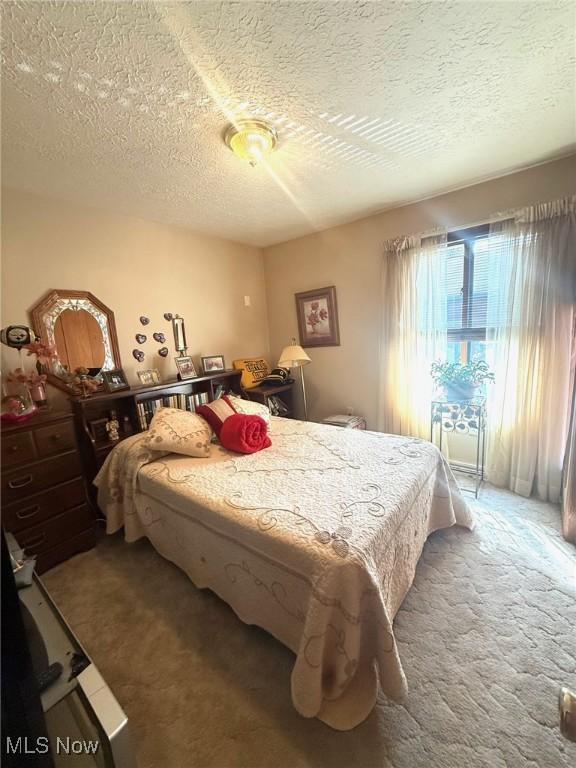 carpeted bedroom featuring a textured ceiling