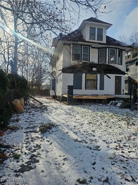 view of snow covered rear of property