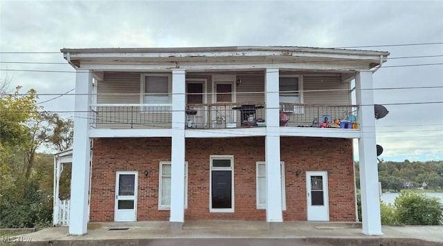 view of front of home with a balcony and brick siding