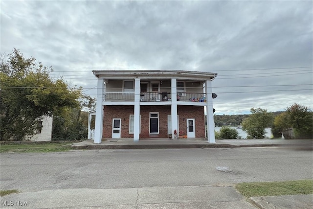 view of front of home featuring a balcony and brick siding