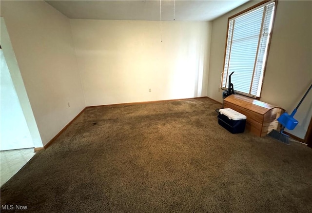 unfurnished room with carpet and baseboards