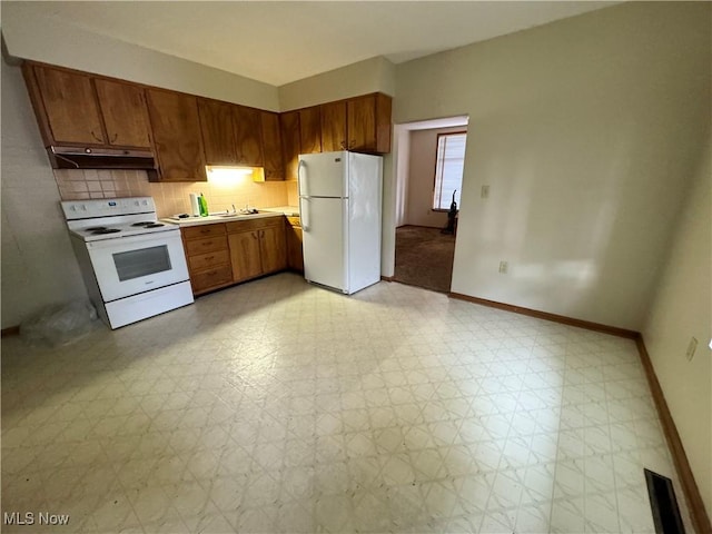 kitchen with white appliances, decorative backsplash, light floors, light countertops, and under cabinet range hood