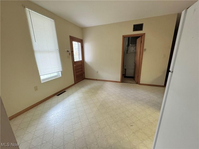 unfurnished room featuring light floors, baseboards, and visible vents