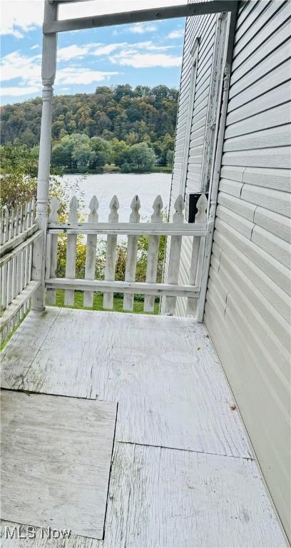 view of patio / terrace featuring a water view and a wooded view