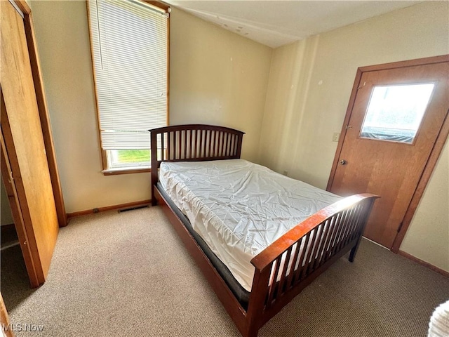 carpeted bedroom featuring visible vents and baseboards