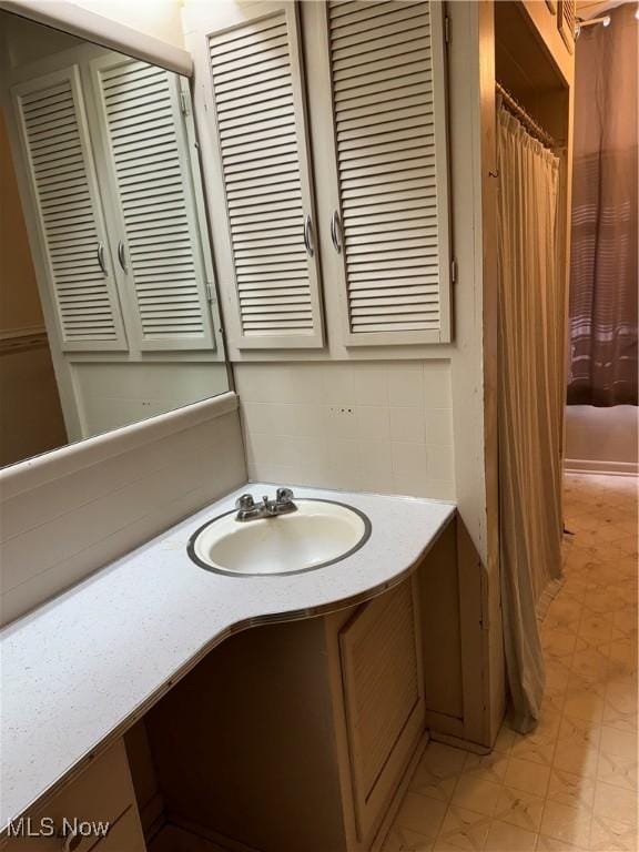 full bathroom with curtained shower, vanity, and tile patterned floors