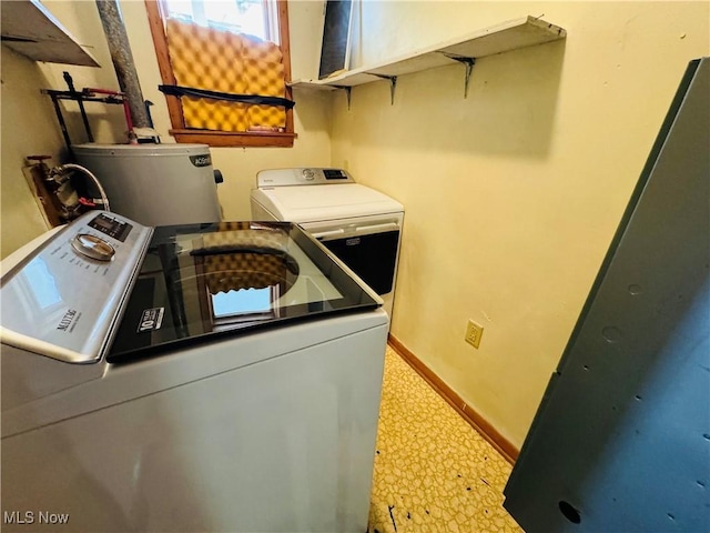 laundry area featuring laundry area, baseboards, tile patterned floors, washing machine and clothes dryer, and water heater