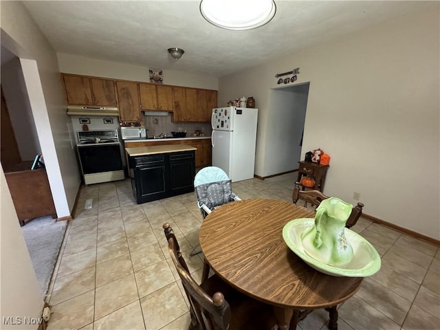 dining room featuring baseboards and light tile patterned flooring