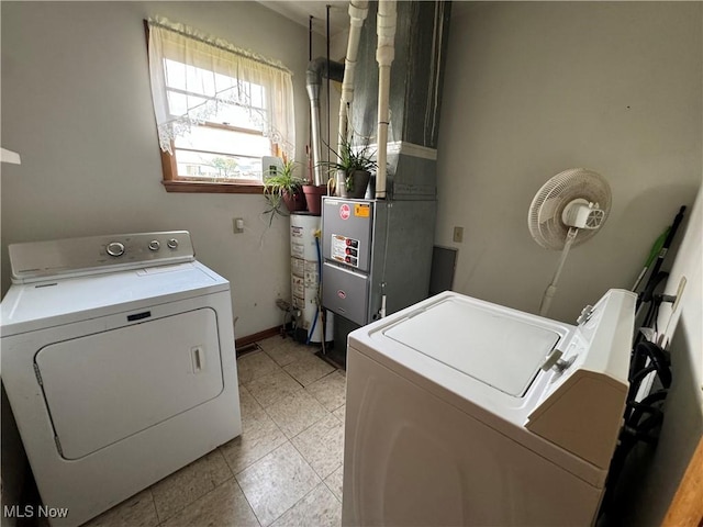 laundry room with light tile patterned floors, water heater, washer and dryer, laundry area, and baseboards