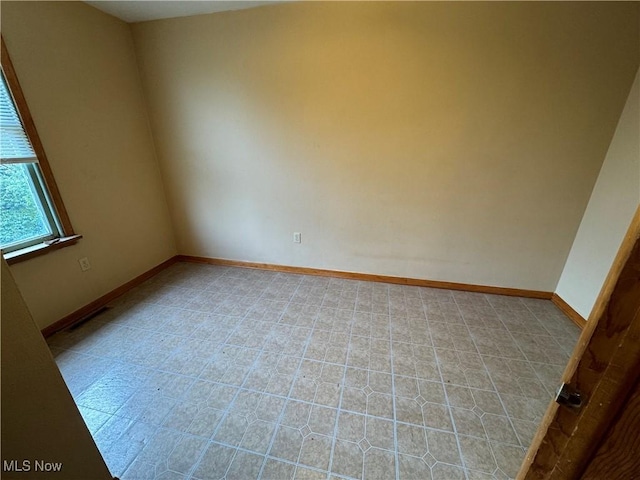 unfurnished room with visible vents and baseboards