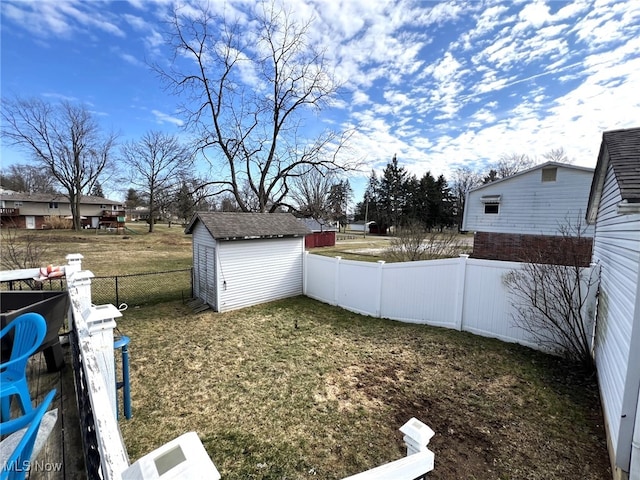 view of yard with an outbuilding, a storage shed, and a fenced backyard