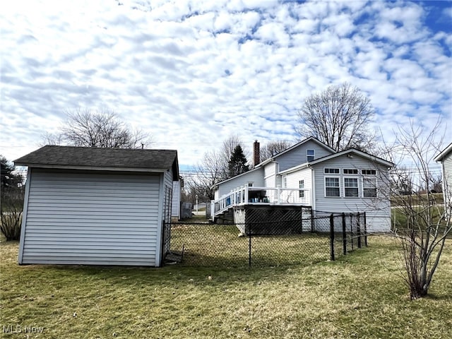 view of yard with a shed, an outdoor structure, a deck, and fence