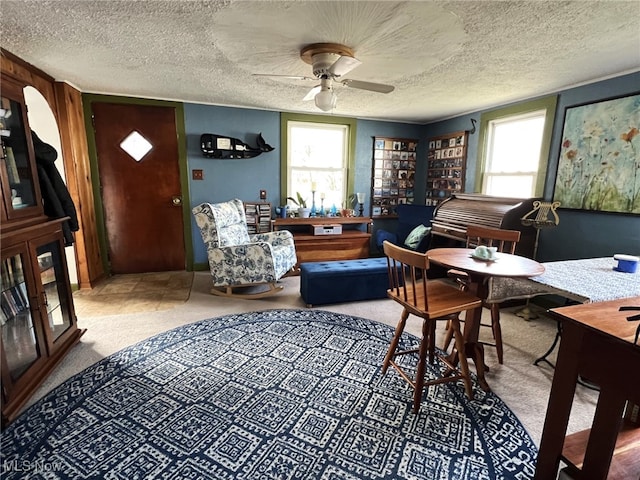 sitting room with carpet, ceiling fan, a textured ceiling, and plenty of natural light