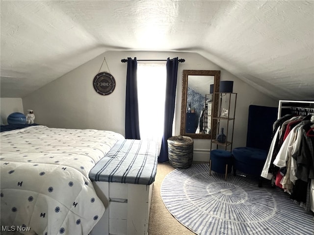 carpeted bedroom with lofted ceiling and a textured ceiling