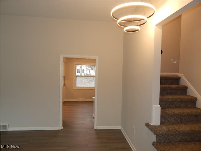 stairs featuring visible vents, baseboards, and wood finished floors