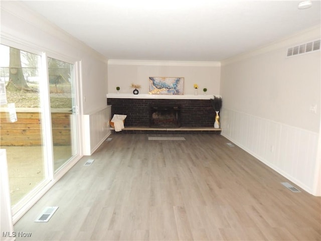 living area featuring a wainscoted wall, a fireplace, and visible vents